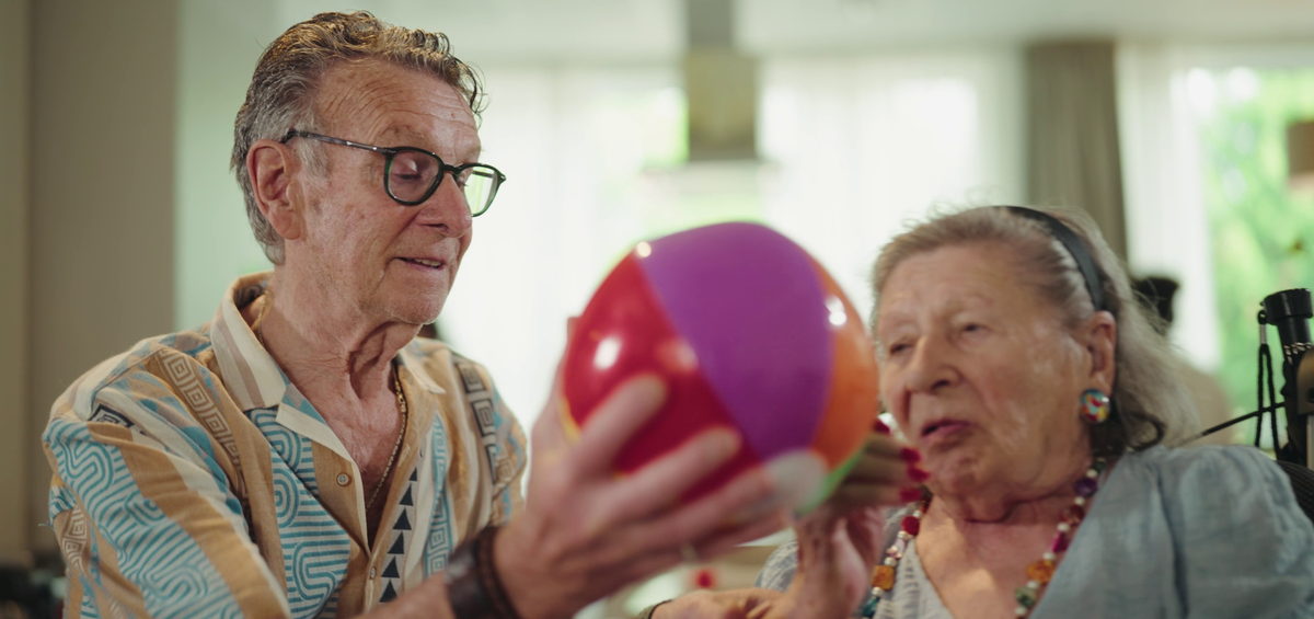 Bewoners spelen samen met een strandbal tijdens een activiteit in de ouderenzorg